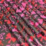 Kadopapier / inpakpapier `Roze en rode strikjes op donkere basis`  ( 30cmx1meter )