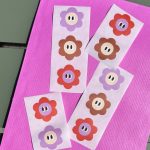 Sticker bloemetje 29mmx31mm `Bloemetjes mix met oogjes` bruin rood lila ( mix van 10 stuks )